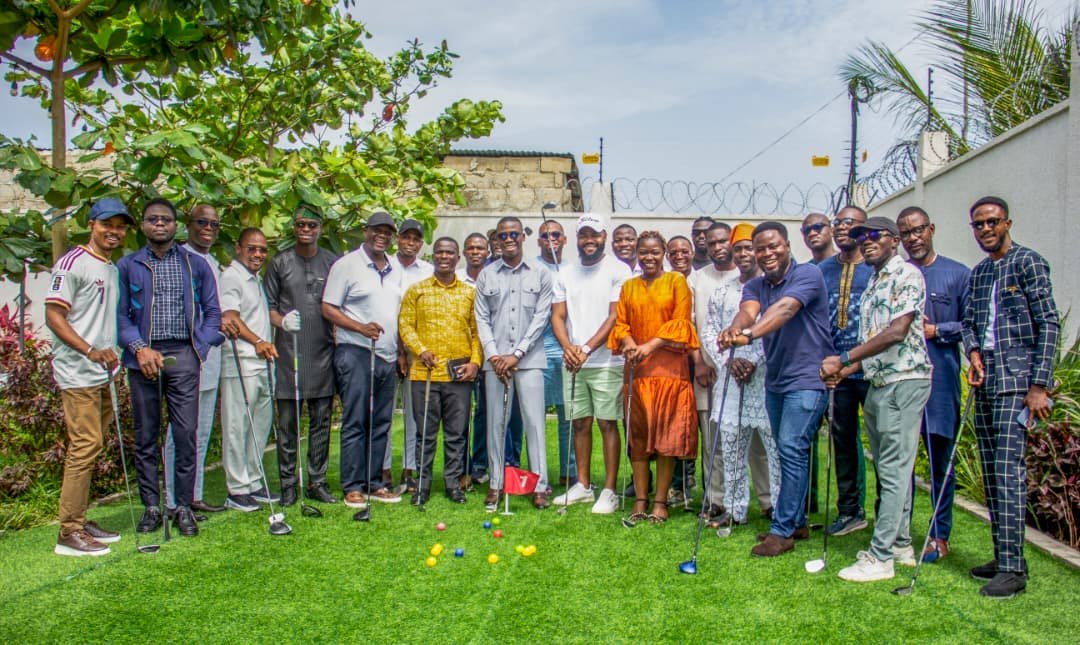 Groupe d’invités posant avec leurs clubs de golf sur le putting green de la villa