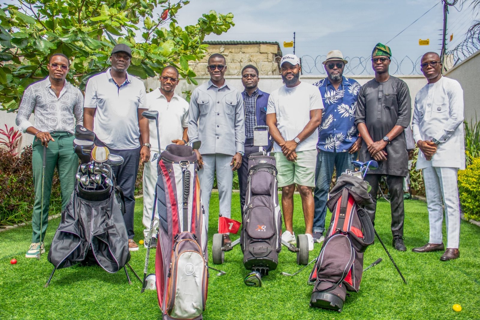 Neuf invités et leurs sacs de golf dans le jardin de la villa